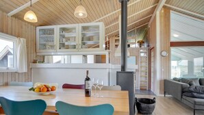 A modern kitchen with wooden cabinets, a central island, and a built-in stove.