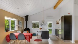 A modern kitchen with a black refrigerator, a dining area with a red tablecloth, and a large window. - "Aarthi" - 637m from the sea by Interhome (Hjørring)
