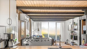 Une cuisine moderne avec un plafond en bois, une grande cuisinière, un évier et une fenêtre avec des rideaux.