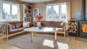 A cozy living room with a fireplace, leather sofas, a coffee table, and a bookshelf. - "Afrim" - 694m from the sea by Interhome (Hjørring)
