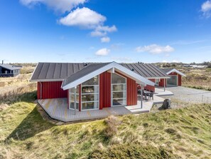 A modern, red-roofed building with large windows and a covered outdoor seating area. - "Björnstjerne" - 400m from the sea by Interhome (Hjørring)