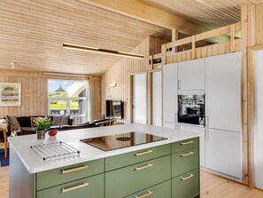 A modern kitchen with a central island, white cabinets, and a view of the outdoors.
