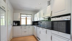 Eine moderne Küche mit weißen Schränken, einer schwarzen Arbeitsplatte und einem Edelstahlbackofen.