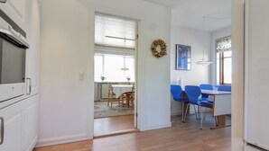 Eine moderne Küche mit weißen Schränken, einer eingebauten Mikrowelle und einem großen Fenster.