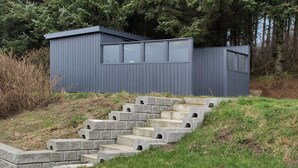 Ein modernes Gebäude mit grauer Fassade und einer Treppe aus Beton.