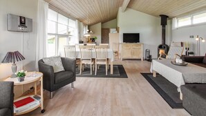 Ein gemütliches Wohnzimmer mit Kamin, Essbereich und Küche.