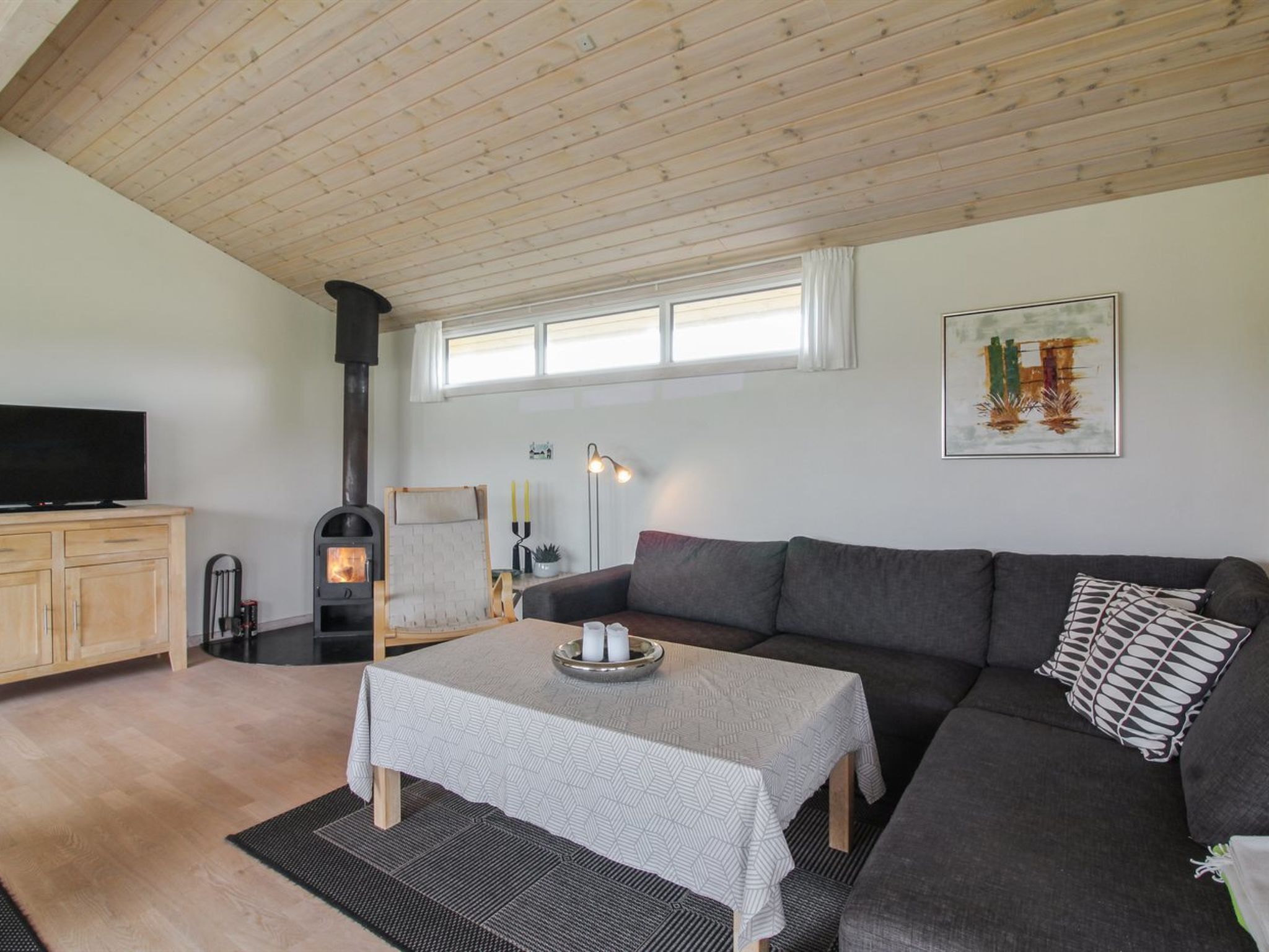 Ein gemütliches Wohnzimmer mit Kamin, einer Couch, einem Fernseher und einem Esstisch.