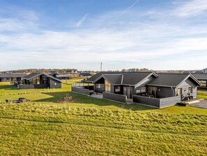 Et moderne boligområde med flere huse med skrå tage og store vinduer.