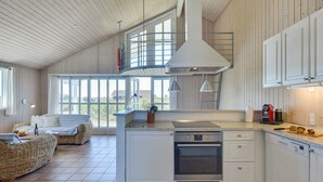 A spacious kitchen with a central island, a built-in oven, and a dishwasher.