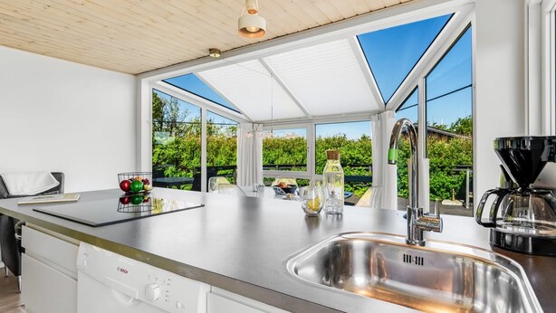 Een moderne keuken met een Bosch vaatwasser, een roestvrijstalen spoelbak en een koffiezetapparaat.