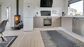 Une cuisine moderne équipée d’un poêle à bois, d’un four à micro-ondes et d’un lave-vaisselle.