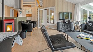 Un salon moderne avec une cheminée, des meubles en cuir et une grande fenêtre.