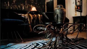 A room with a zebra-patterned rug, a metal table with a vase, and a lamp in the background. - Bohemian Rhapsody King Suite St. Augustine at WGV (St. Augustine)
