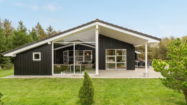 A modern house with a large glass window, a covered patio, and a well-maintained lawn. - "Frida" - 700m from the sea by Interhome (Fjerritslev)