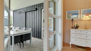 A modern interior with a dining area, a white dresser, and a wooden wall. - "Frida" - 700m from the sea by Interhome (Fjerritslev)