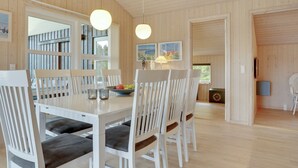 A dining area with a wooden table and chairs, pendant lights, and a view of the outdoors. - "Frida" - 700m from the sea by Interhome (Fjerritslev)
