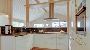 A modern kitchen with white cabinets, a wooden floor, and a large window. - "Frida" - 700m from the sea by Interhome (Fjerritslev)
