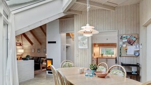 Un espace repas comprenant une table en bois, des chaises et un luminaire suspendu.