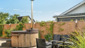 Eine Terrasse mit Kaminofen, Sitzgelegenheiten im Freien und einer Holzterrasse.