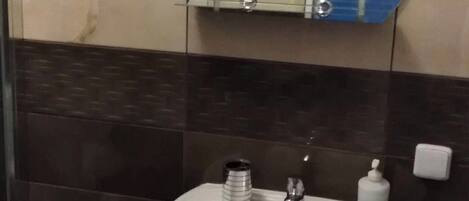 A bathroom with a white sink, a mirror, and a blue-framed mirror.