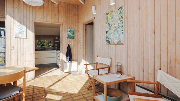 A wooden interior with a dining area, a kitchen, and a bathroom. - "Roulf" - 1.1km from the sea by Interhome (Fjerritslev)