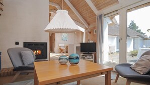 A cozy living room with a fireplace, wooden ceiling, and a large window. - "Roulf" - 1.1km from the sea by Interhome (Fjerritslev)