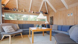 A cozy room with a wooden ceiling, a sofa, a chair, a small table, and a lamp. - "Roulf" - 1.1km from the sea by Interhome (Fjerritslev)