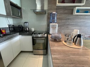 Appartement | Privékeuken | Een koelkast, een magnetron, een blender, kookgerei, borden en bestek