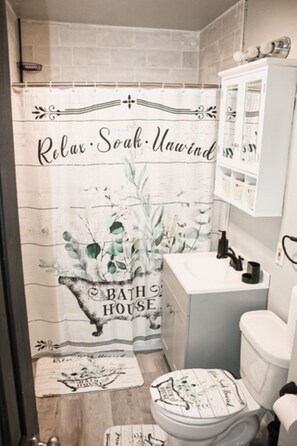 Experience a tranquil bathroom retreat with a shower, sink, toilet, and storage cabinet.