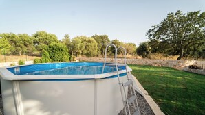 An above-ground swimming pool with a ladder, surrounded by a stone wall and a grassy lawn. - 2 Bedroom Private vacation home in Monopoli (Monopoli)