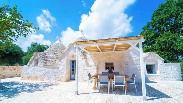 A stone building with a covered patio area, a table, and chairs. - 2 Bedroom Private vacation home in Monopoli (Monopoli)