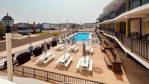 A hotel balcony with a pool, outdoor seating, and a view of the street. - Settle In the Sun!
Fantastic centrally located North Wildwood Condo  (North Wildwood)