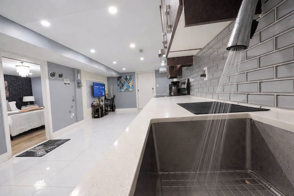 A modern kitchen with a built-in oven, a sink, and a backsplash.