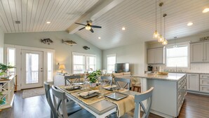A spacious kitchen with a dining area, wooden ceiling, and a view of the ocean. - Resort Perks: Waterfront Rockport Home! (Rockport)
