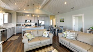 A spacious living area with a sofa set, a dining table, and a kitchen in the background. - Resort Perks: Waterfront Rockport Home! (Rockport)