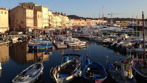 A marina with boats docked, buildings along the waterfront, and a clear sky. - Sur les pas de Pagnol (Aubagne)