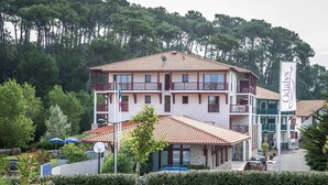 A two-story hotel with a tiled roof, balconies, and a sign reading "Odals."