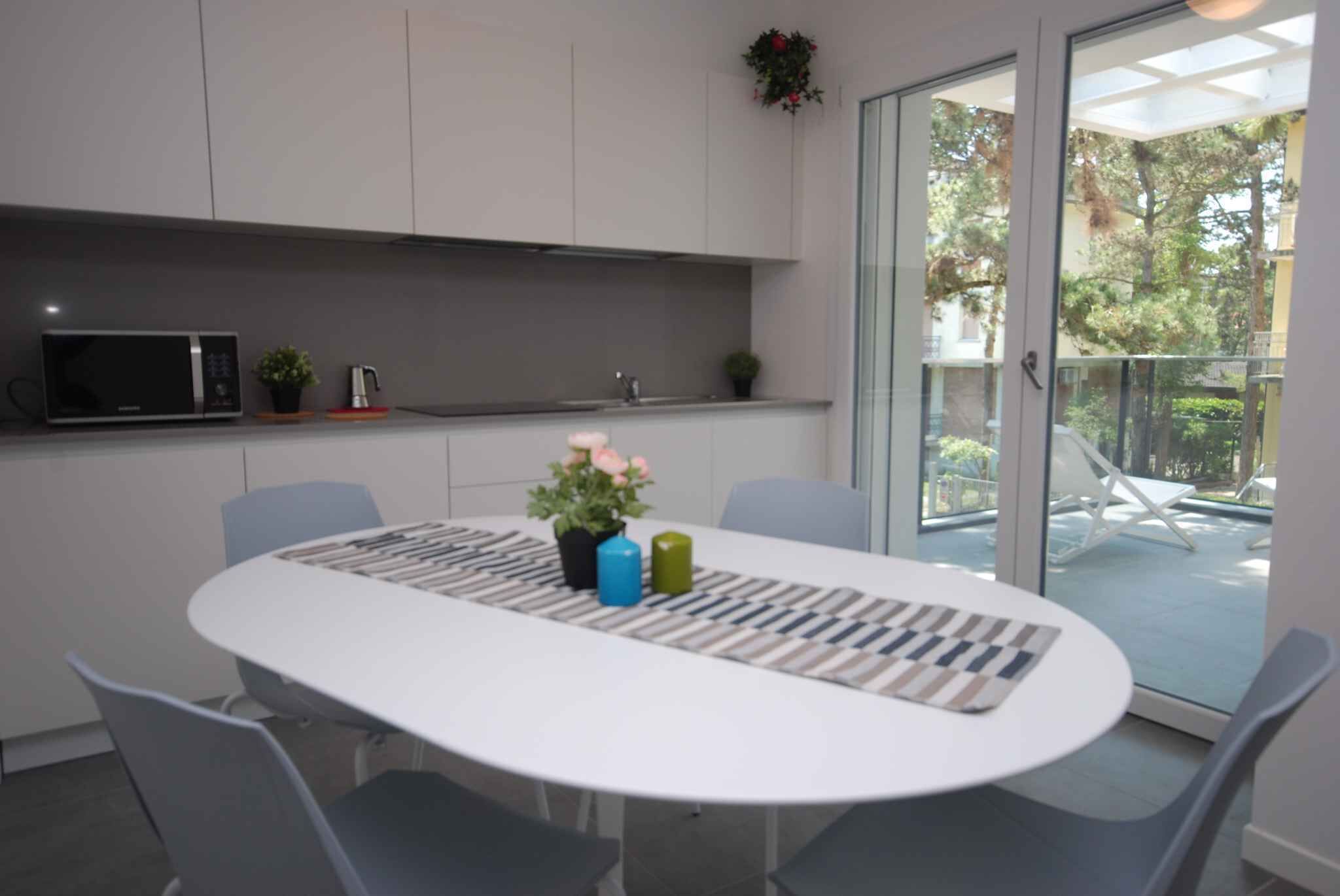 Et moderne køkken med mikroovn, potteplanter og et spiseområde med bord og stole.