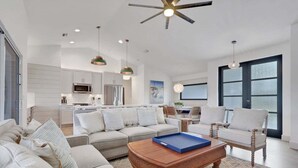 A spacious living room with a sectional sofa, a coffee table, and a dining area with chairs.