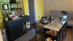 A compact living space with a kitchenette, dining area, and a sofa.