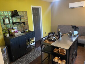 Un espacio habitable compacto con kitchenette, comedor y sofá.