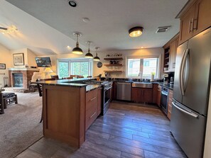 A modern kitchen with a central island, built-in appliances, and pendant lighting.