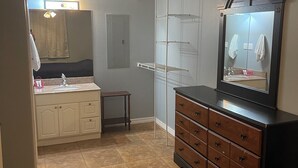 A bedroom with a bed, dresser, vanity, and a walk-in closet. - Whiskey Bay Lodge #2 (Boothville-Venice)