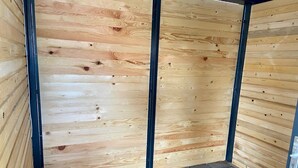 Ein Zimmer mit Holzwänden und Fliesenboden.