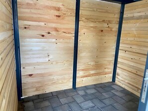Une pièce aux murs en bois et au sol carrelé.