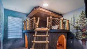 A playhouse with a wooden ladder leading to a rope ladder on the roof, surrounded by a forest mural. - Waterpark, Arcades, Pool Table, Drive-in Theater, Poker Table: Treasured Days (Davenport)