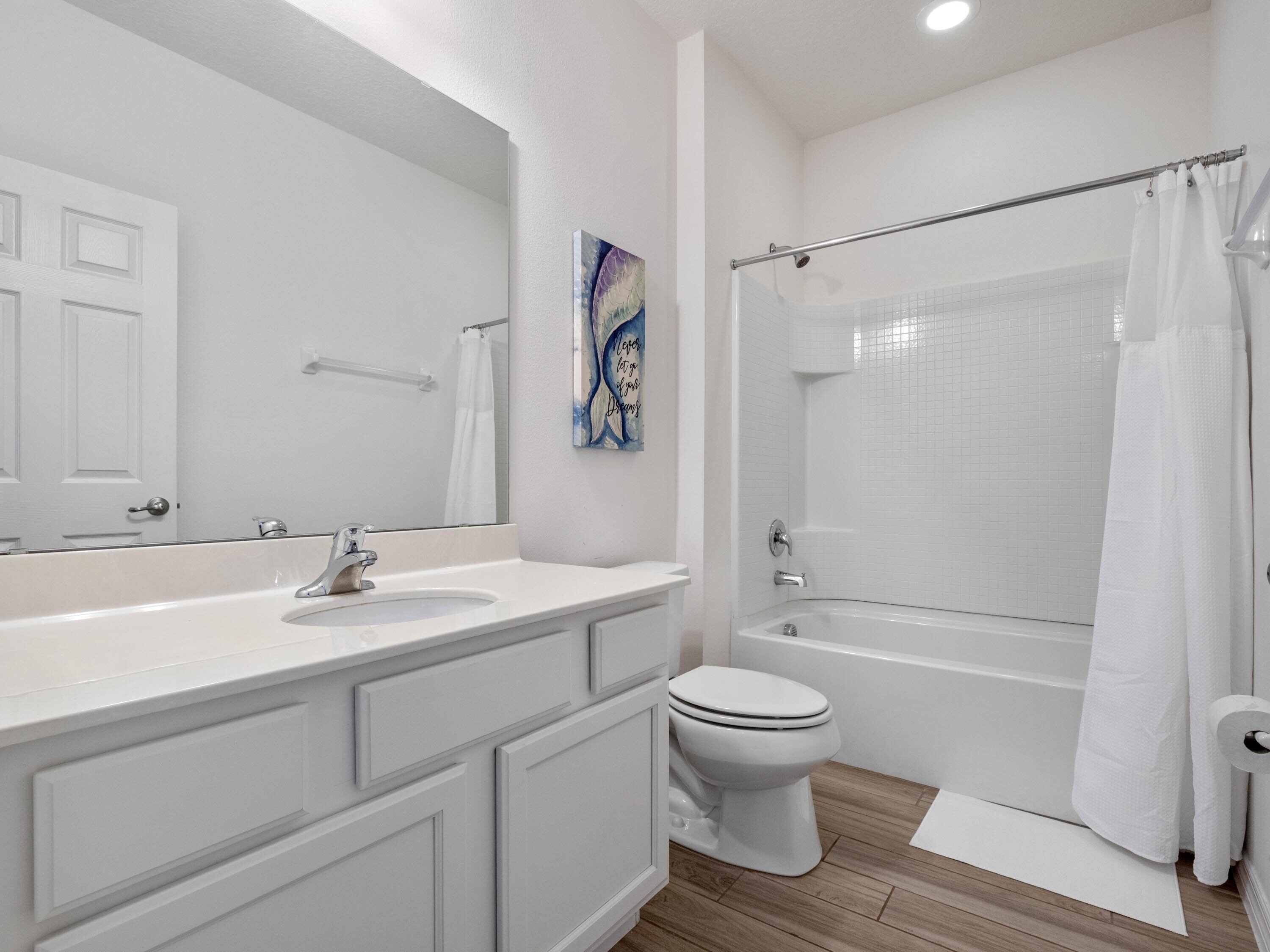 Un baño moderno con lavamanos, inodoro y bañera blancos.