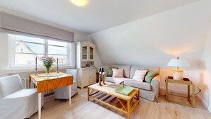 Een moderne woonkamer met een bank, salontafel, eettafel en een lamp.
