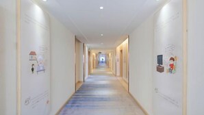 A long, narrow hotel corridor with a blue-striped carpet, white walls, and ceiling lights. - Vienna 3 Best Hotel (Changsha Wangcheng Economic Development Zone) (Changsha)