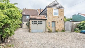 A two-story house with a gravel driveway, a front garage, and a small garden area. - Harbour View, Walberswick (Walberswick)